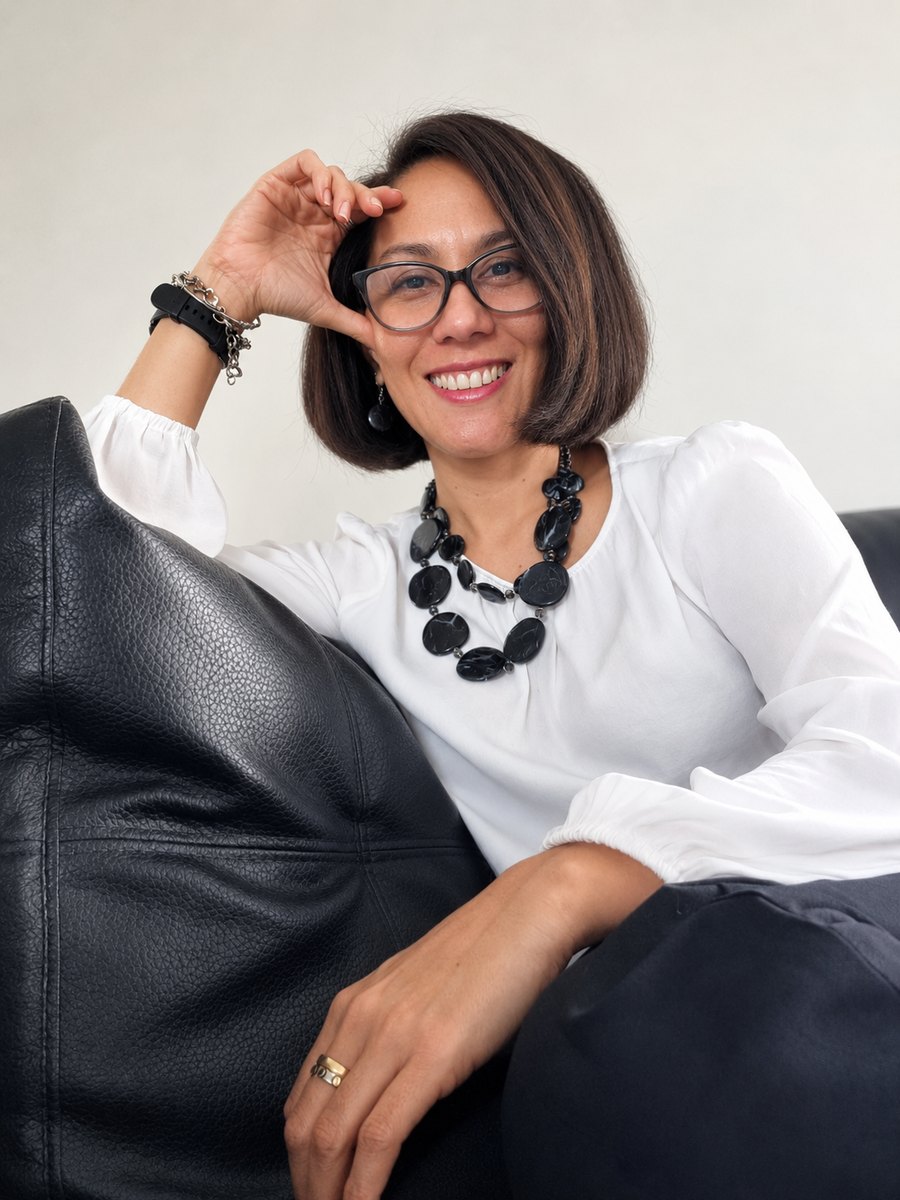 Mitzi Johnson sentada en un sofá, sonriendo a la cámara